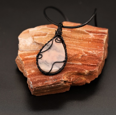 Watermelon Marble pendant with black cloud patterns and a black wire weave wrap.